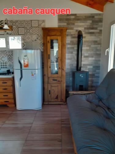 a kitchen with a white refrigerator and a door at Cabañas Los Teros in Aluminé