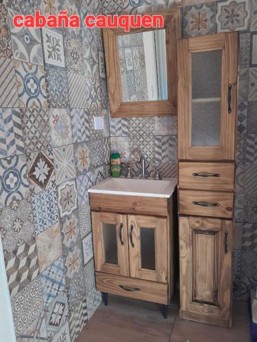 a bathroom with a sink and a mirror at Cabañas Los Teros in Aluminé