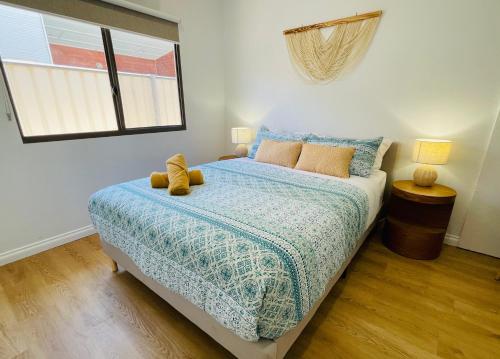 a bedroom with a bed with two teddy bears on it at Sunrise Beach Hideaway in Exmouth