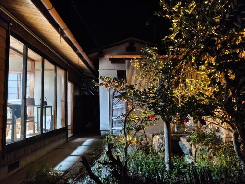 a building with windows and a tree in front of it at Walkable retro town , Supermarkets nearby,高野口ガッコーチカクのゲストハウス in Hashimoto