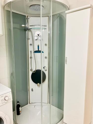 a shower with a glass door in a bathroom at Sunshine centrum in Koksijde