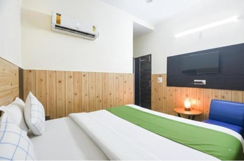 a bedroom with a bed and a flat screen tv at Hotel Red ark inn in Mohali
