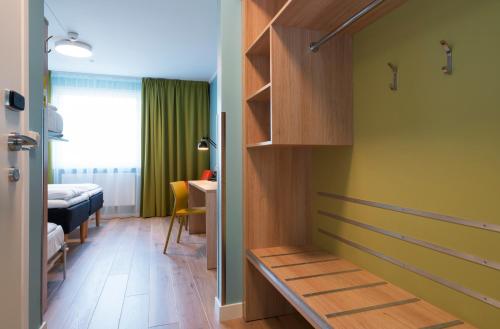 a room with a hallway with a bench and a bed at Thon Hotel Gardermoen in Gardermoen