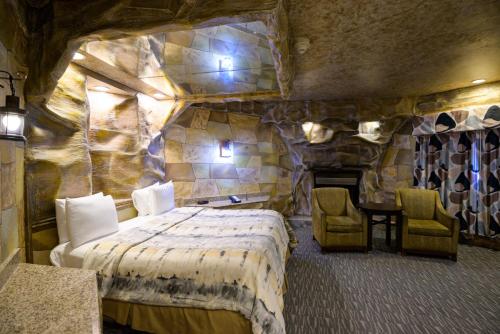 a bedroom with a bed and a stone wall at Inn of The Dove Romantic Luxury & Business Suites in Bensalem
