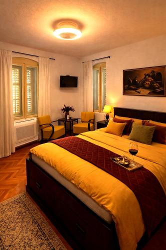 a bedroom with a large bed with a yellow blanket at Tri srca 2 - De Luxe 2 in Trebinje