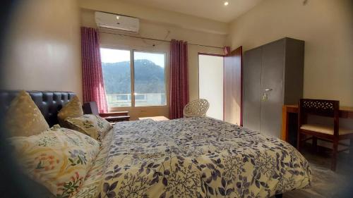 a bedroom with a bed and a window at Nileshwar Home Stay in Bāgeshwar