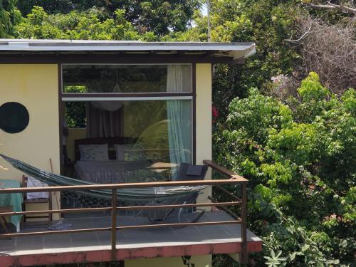 a hammock on the porch of a house at Pousada VillaBahia Morro in Morro de São Paulo