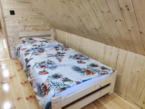 a bedroom with a bed in a wooden room at Duży dom w lesie in Zatory