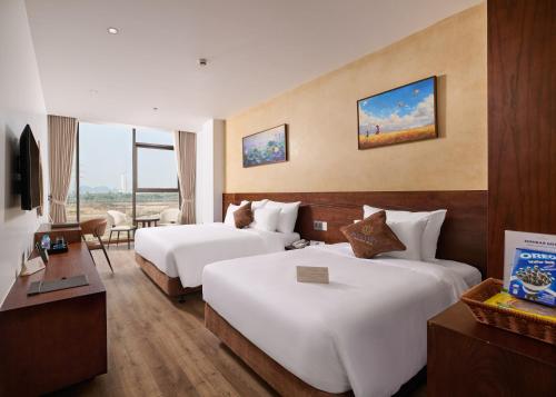 a hotel room with two beds and a television at Elegance Ninh Binh Hotel in Kỳ Vĩ