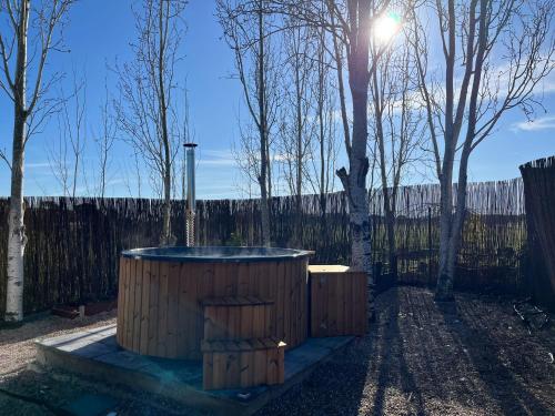 a wooden hot tub in a yard with trees at Alentejo Villa Nordic Spa & Pool in Santo António do Alcôrrego