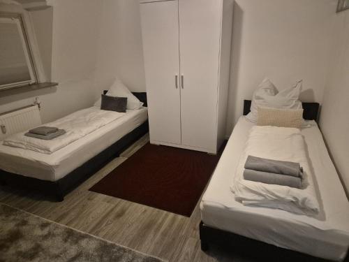 a room with two beds and a cabinet in it at Waterloo Sunset Hotel in Erzhausen