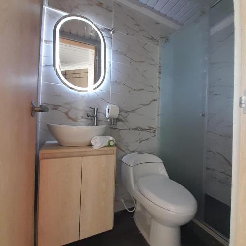 a bathroom with a toilet and a sink and a mirror at La Casa De Mi Tatis in Salento