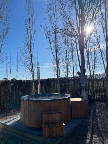 a hot tub sitting next to a tree at Alentejo Villa Nordic Spa & Pool in Santo António do Alcôrrego