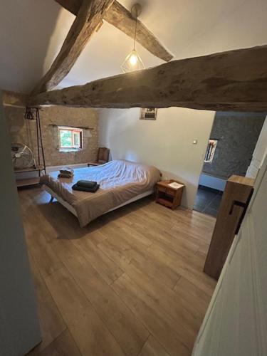 a bedroom with a bed and a wooden floor at Poitevins in Saint-Astier