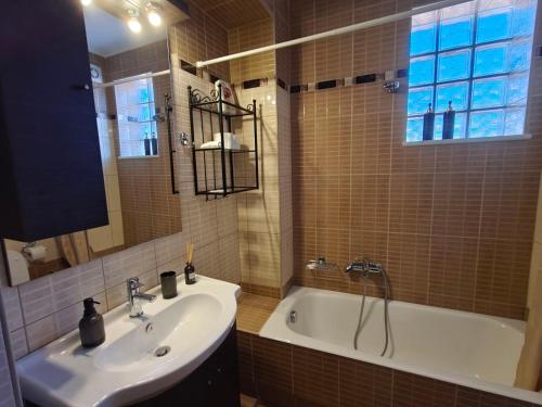 a bathroom with a sink and a bath tub at Metsovo Fireplace Retreat I in Metsovo