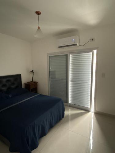 a bedroom with a bed and a window with a air conditioner at Rivadavia Confort in Mariano J. Haedo