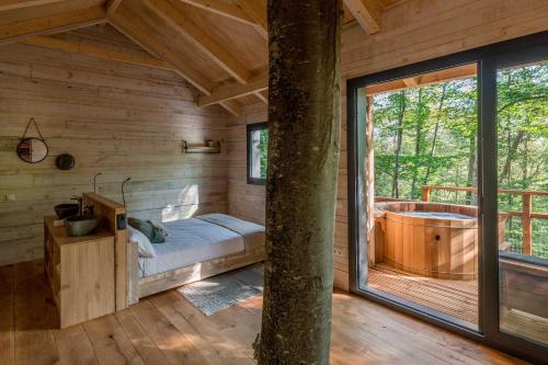 a bedroom with a large window and a tub in a cabin at Cabanyes entre Valls in Vall de Bianya