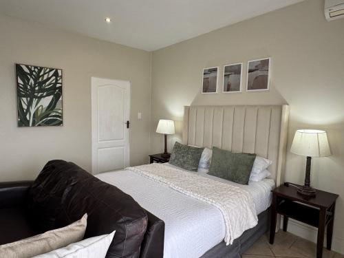 a bedroom with a large bed and a couch at The olive stay at Ocean view Villas F7 in Port Edward