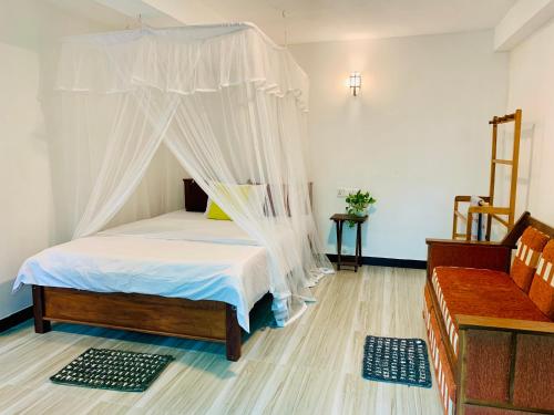 a bedroom with a bed with a mosquito net at Happy Rest House Ella in Ella