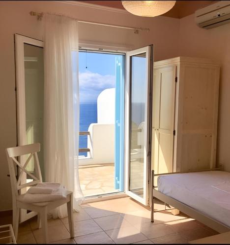 a bedroom with a bed and a sliding glass door at Mykonos Dot - The Villas in Mikonos