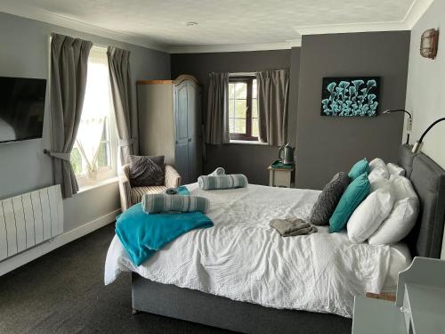 a bedroom with a large bed with blue and white pillows at Plough inn in Great Mongeham