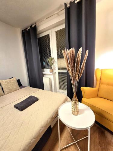 a bedroom with a bed and a table and a chair at Apartmán Bratislava Ružinov in Nivy