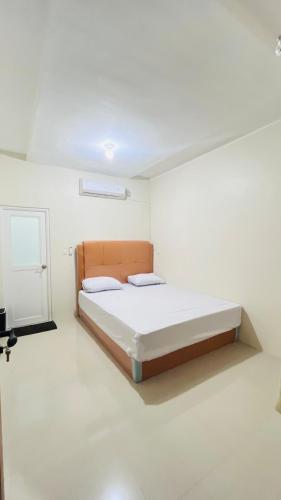 a bedroom with a bed in a white room at Mulei homestay in Wainapal
