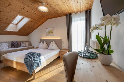 a bedroom with a bed and a table and a couch at Burgunderhof in Montagna