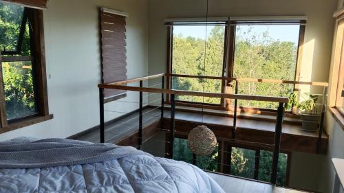 a bedroom with a bed and a large window at El Estuario Niebla Cabin in Niebla