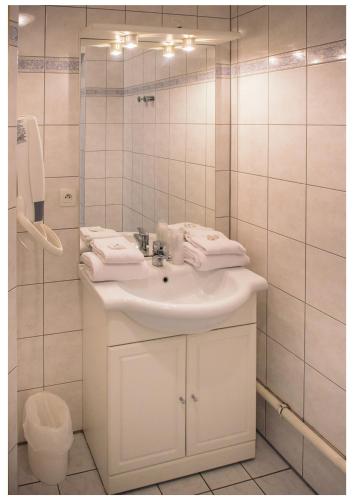 une salle de bain blanche avec un lavabo et un miroir dans l'établissement Residence Le Royal Golf & Horse, à Mooslargue
