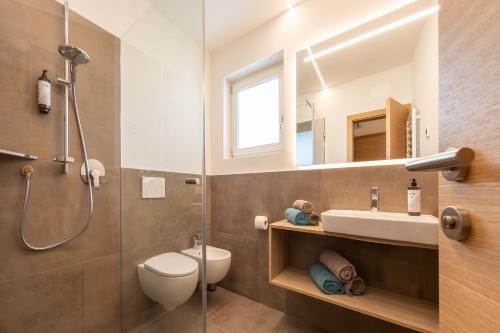 a bathroom with a shower and a toilet and a sink at Burgunderhof in Montagna