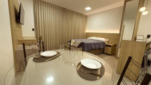 a room with a table with chairs and a bed at Moov Smart Home – Studios e Apartamentos por Temporada em Cuiabá in Cuiabá
