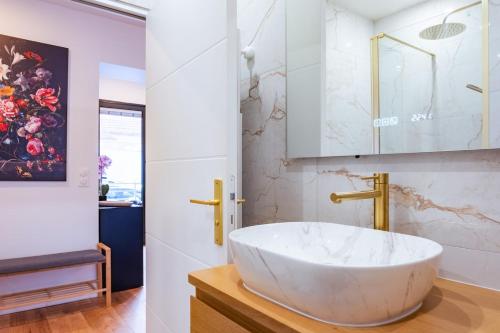 a bathroom with a large white sink and a mirror at Studio Élégant - Proche Paris & La Défense in Rueil-Malmaison