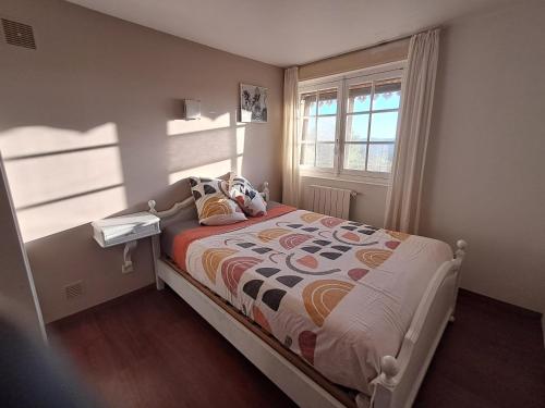 a small bedroom with a bed and a window at Clos des mimosas in Monflanquin
