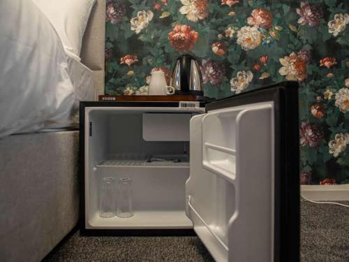 an open refrigerator sitting next to a bed at City Comfort Rooms - Sheffield in Sheffield