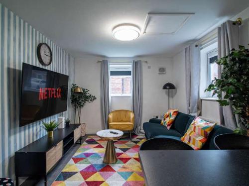 a living room with a couch and a tv at City Comfort Rooms - Sheffield in Sheffield