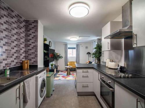 a kitchen with a sink and a dishwasher at City Comfort Rooms - Sheffield in Sheffield