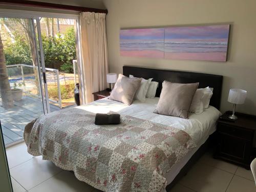 a bedroom with a bed and a large window at Fiori Rosa in Bloemfontein