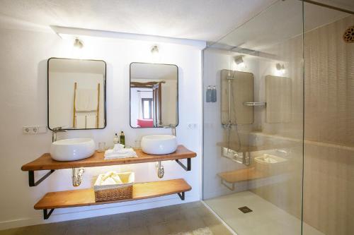 a bathroom with two sinks and a shower at Boutique Hotel Sa Galera in Caʼs Concos