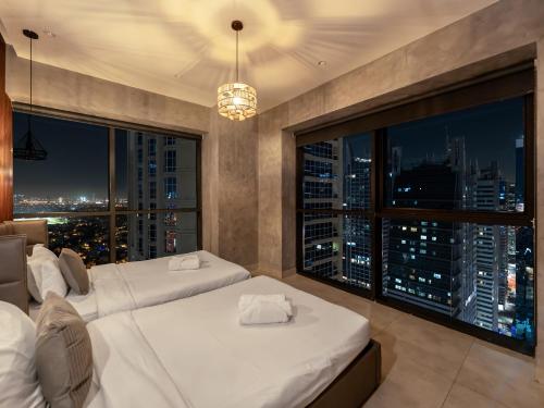 a bedroom with two beds and a large window at Luxury 3 Bedroom Sub Penthouse in Dubai