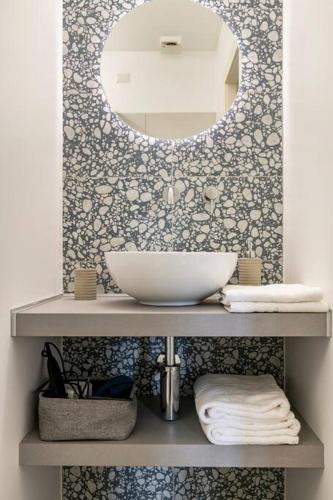 a bathroom with a sink and a mirror on a shelf at Casa Obìa in Cagliari