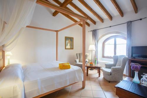 a bedroom with a bed and two chairs and a window at Boutique Hotel Sa Galera in Caʼs Concos