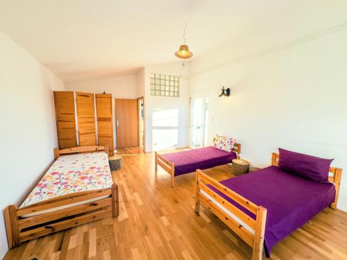 a bedroom with two beds and purple sheets at Haus Ljubica Ražanac in Ražanac