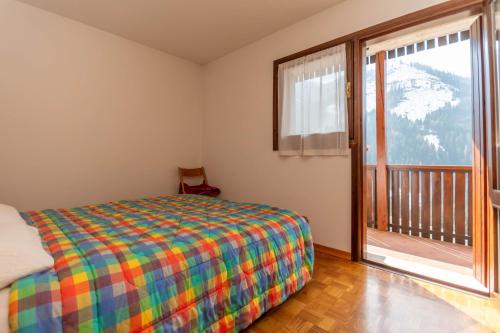 a bedroom with a bed and a large window at Condominio Meraviglia in Selva di Cadore