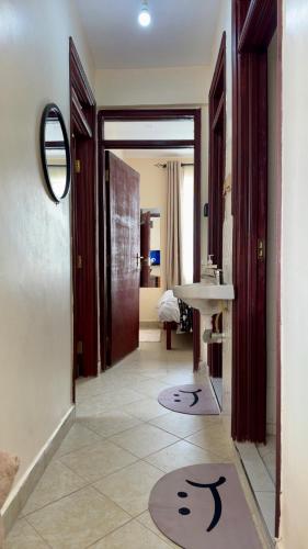 a hallway with a bathroom with a sink and a mirror at My Humble Abode - Machakos in Machakos