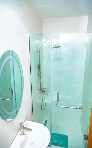 a bathroom with a sink and a glass shower at LetMax Homes in Ikeja