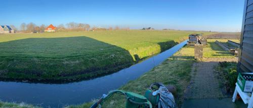 a boat is parked on the side of a river at Oomes Huus - Sleep by Hästens, Wake with Coffee in Den Hoorn