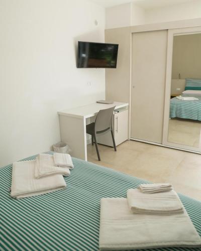a bedroom with a bed and a desk with a mirror at Otium Mare Felix in Stazione di Paestum