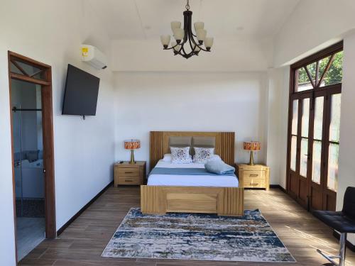 a bedroom with a bed and a tv on the wall at Casa Colonial Maria Elena in Pereira