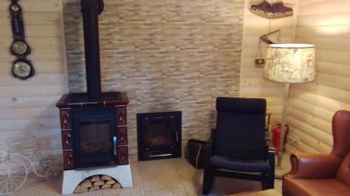 a living room with a wood stove and a chair at Arturas Guest House in Vilnius